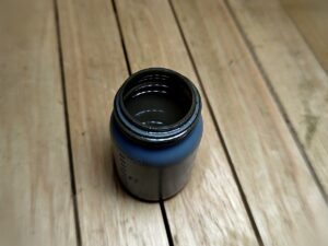 オイル添加剤の小瓶（Black の名前の由来になった黒い中身）
