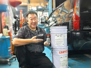 5W-30 のペール缶とオイル添加剤を持つ平山